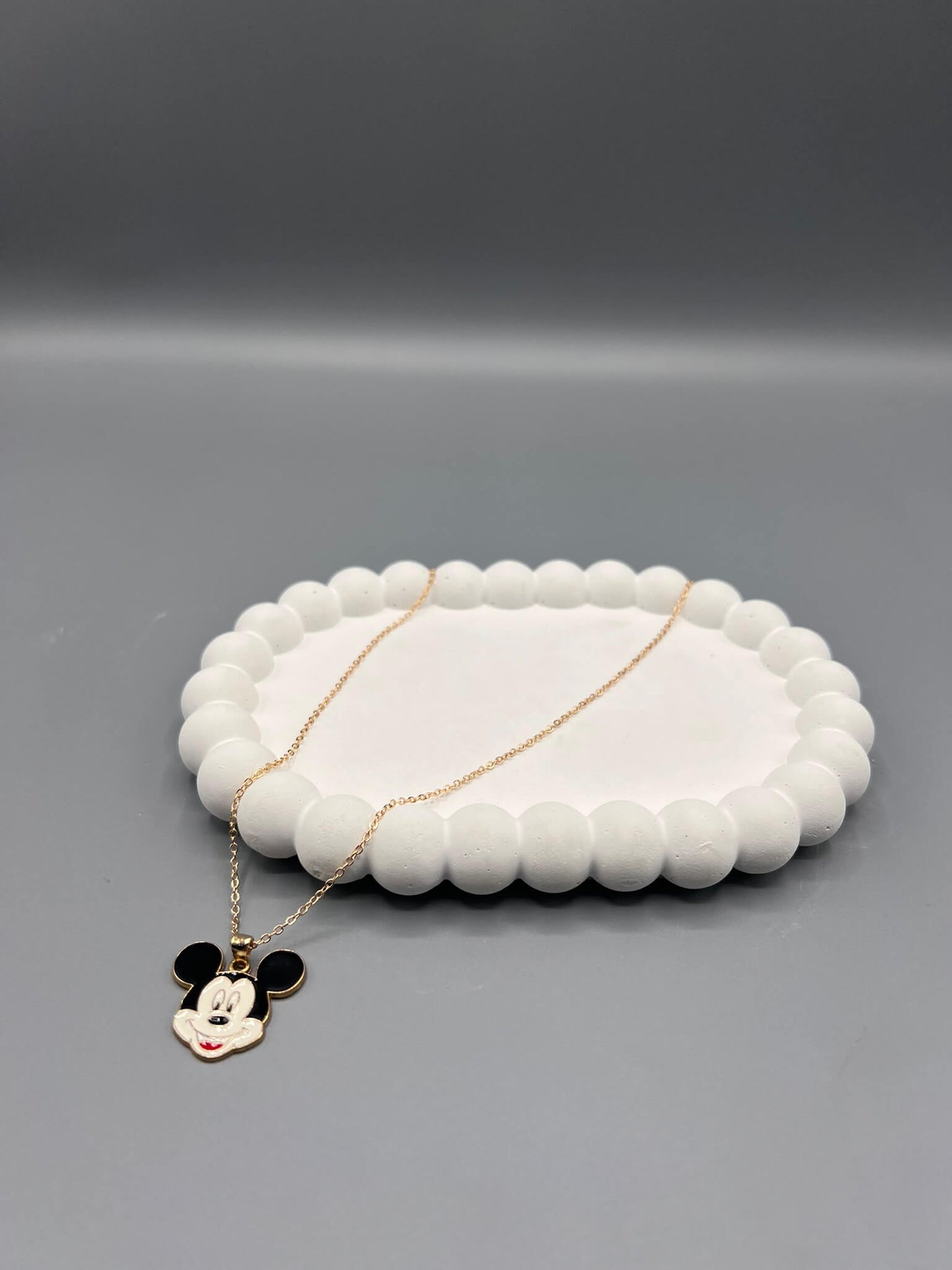 Mickey Mouse & Daisy Duck pendant. pendant necklace with a gold-toned chain and a black and white enamel pendant