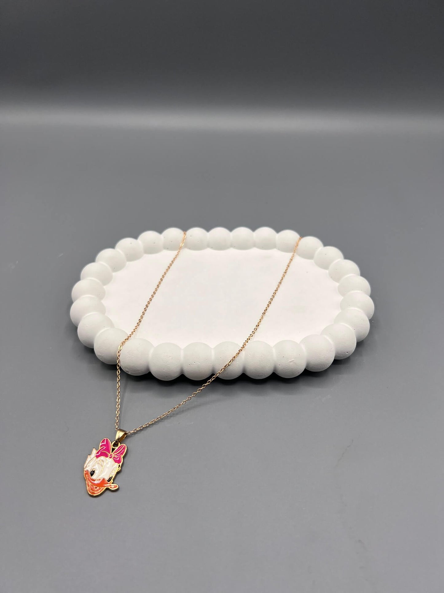 Mickey Mouse & Daisy Duck pendant. pendant necklace with a gold-toned chain and a black and white enamel pendant