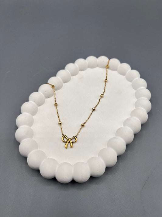 This is a gold-plated stainless steel bow necklace