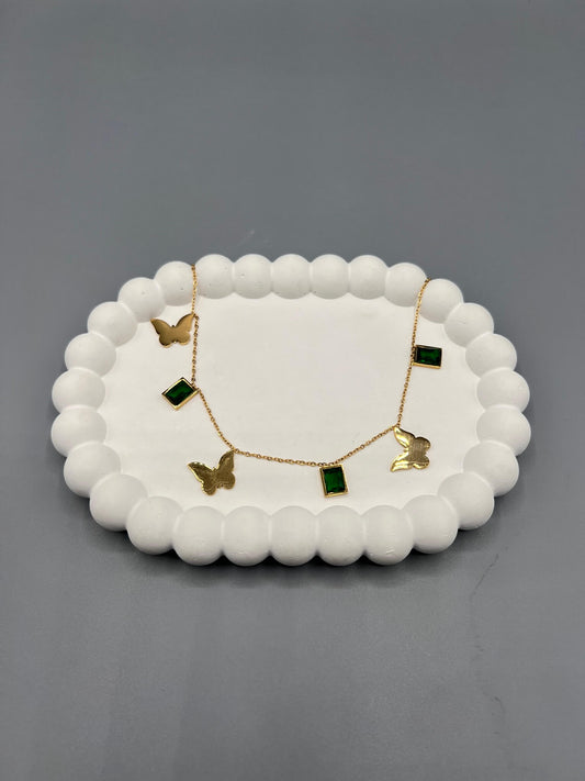 The item shown is a gold-toned necklace with butterfly and green stone charms.